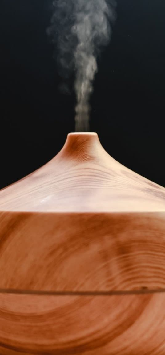 A wooden diffuser releasing mist